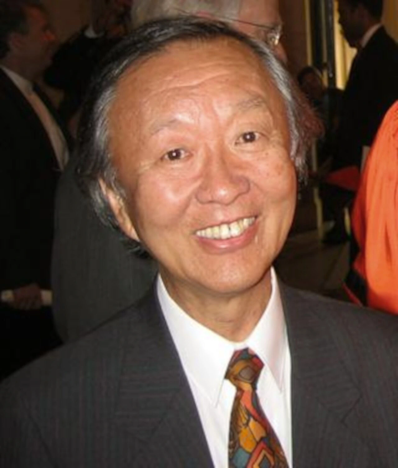 Charles K. Kao smiling in a suit and tie at an event